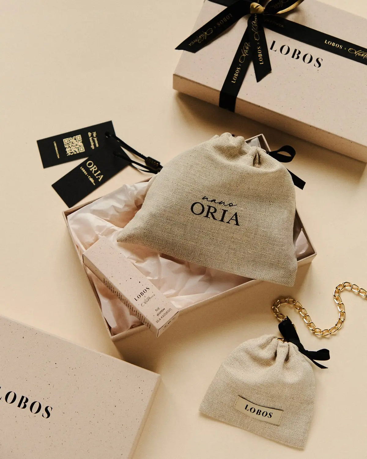 The open ORIA box: nano ORIA linen pouch, perfume carton, tags and the gold chain