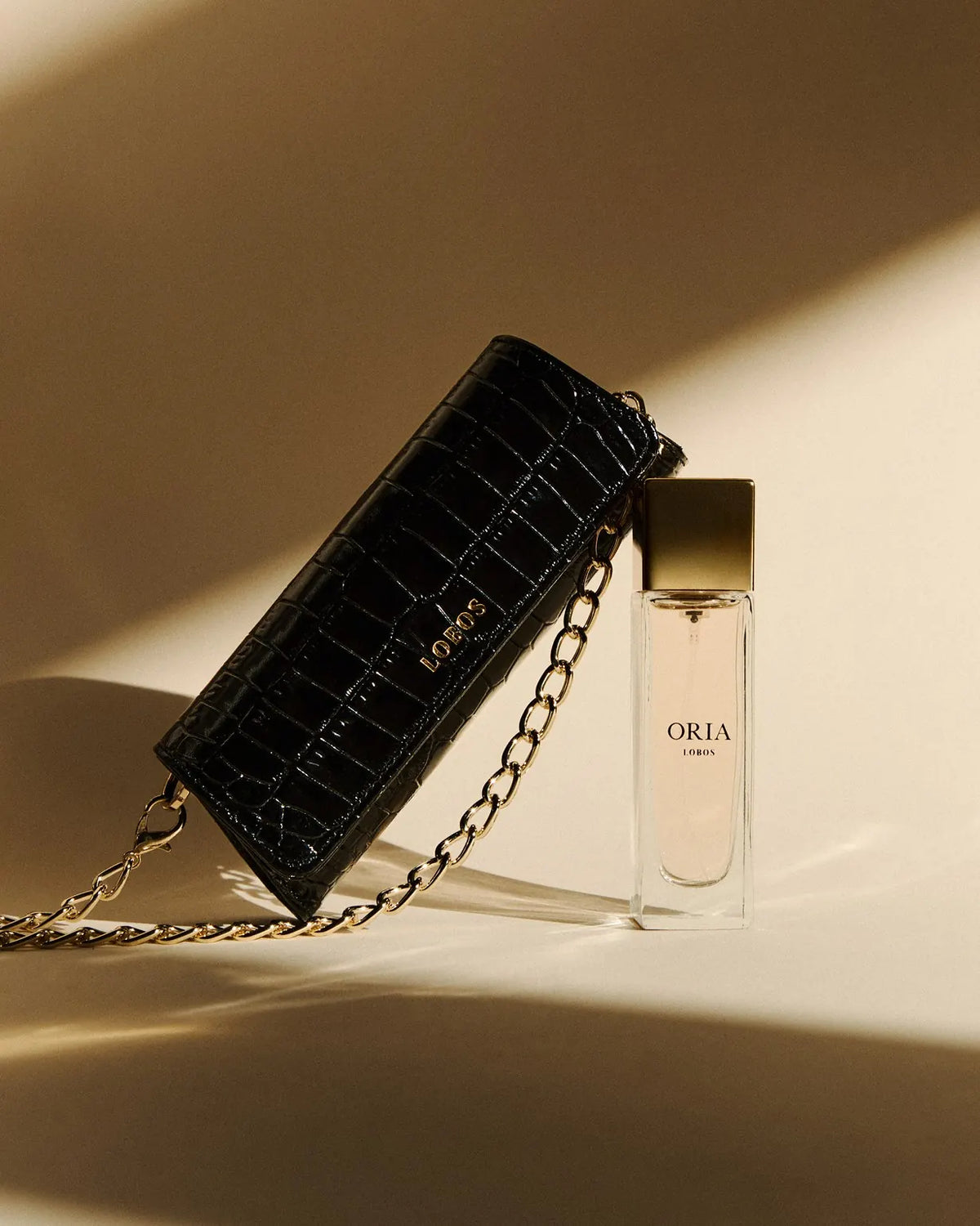 The Nano ORIA set: black croc Nano on a gold chain, the ORIA bottle and the card illustrated by Anna Halarewicz